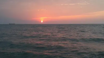 a sunset over the ocean with the sun in the horizon at Oasis de Tolú in Tolú