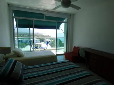 a bedroom with a bed and a window with a view at Costa Azul Suites 905 in Santa Marta