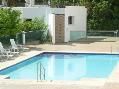 a large swimming pool with chairs and a house at Costa Azul Suites 905 in Santa Marta