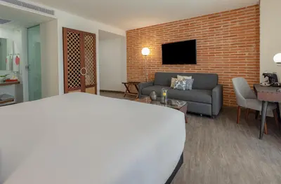 a living room with a couch and a brick wall at Hotel Santa Catalina By OxoHotel in Cartagena de Indias