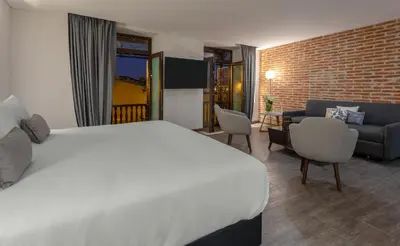 a hotel room with a bed and a brick wall at Hotel Santa Catalina By OxoHotel in Cartagena de Indias