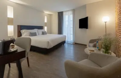 a hotel room with a bed and a couch and chairs at Hotel Santa Catalina By OxoHotel in Cartagena de Indias