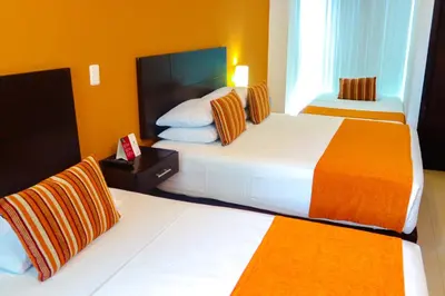two beds in a hotel room with orange walls at Hotel Buenos Aires in Cartagena de Indias