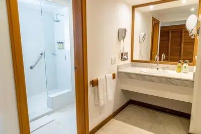 a bathroom with a shower and a sink and a mirror at Hotel Irotama XXI in Santa Marta