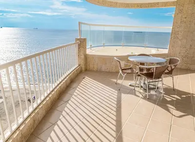 a balcony with a table and chairs and the ocean at Hotel Irotama del Sol in Santa Marta