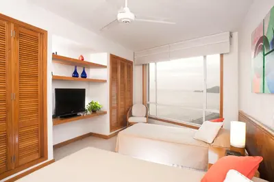 a bedroom with a bed and a tv and a window at Hotel Irotama del Sol in Santa Marta