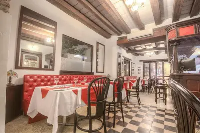 a restaurant with a red couch and tables and chairs at Hotel Monterrey in Cartagena de Indias