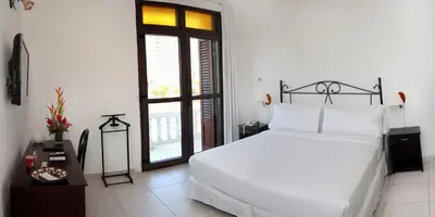 a bedroom with a white bed and a window at Hotel Monterrey in Cartagena de Indias