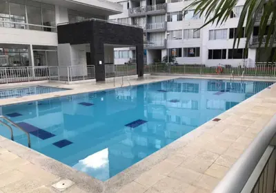 a large blue swimming pool in a building at Apartamento Vacacional En La Zona Norte De Barranquilla in Barranquilla