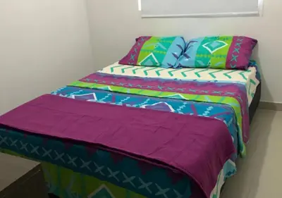 a bed with colorful blankets and pillows in a room at Apartamento Vacacional En La Zona Norte De Barranquilla in Barranquilla