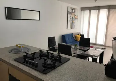 a kitchen with a stove and a living room at Apartamento Vacacional En La Zona Norte De Barranquilla in Barranquilla