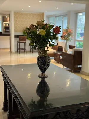 a vase with flowers sitting on top of a table at Vallclaire Suites in Barranquilla