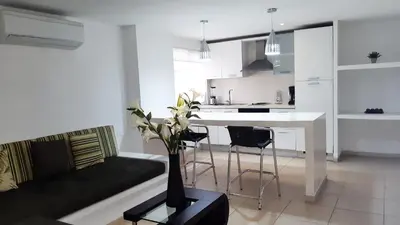 a living room and kitchen with a couch and a table at Vallclaire Suites in Barranquilla