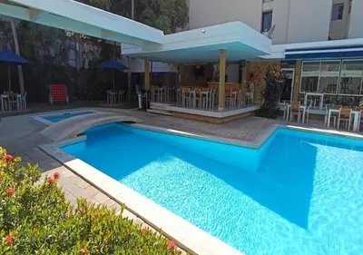 a swimming pool in front of a building at Vallclaire Suites in Barranquilla