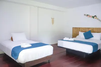 two beds in a room with white and blue at Hotel Isla Palma Reserva Natural in Isla Palma