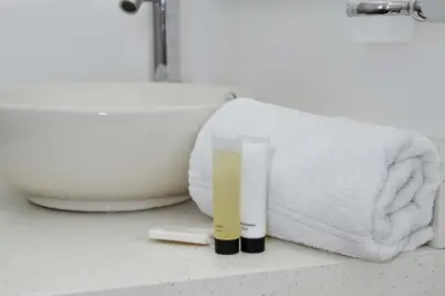 a bathroom sink with a towel and a tube of toothpaste at Hotel Casa Nico in Barranquilla