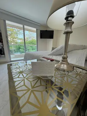 a glass table with a lamp and a laptop on it at Hotel Casa Nico in Barranquilla