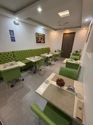 a restaurant with green tables and green chairs at Hotel Casa Nico in Barranquilla