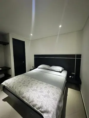 a bedroom with a bed with a black headboard at Hotel La Esperanza in Cartagena de Indias