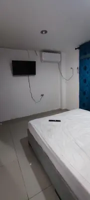 a room with a bed with a tv on the wall at Posada Dakema in Cartagena de Indias