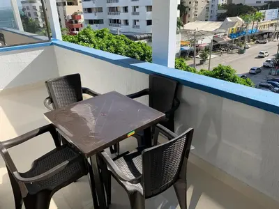 a table and chairs on a balcony with a view of a city at Portofino Cartagena Bocagrande By ICDI in Cartagena de Indias