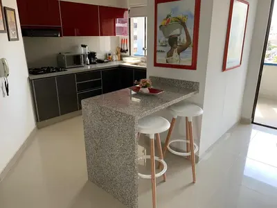 a kitchen with a counter and stools in it at Portofino Cartagena Bocagrande By ICDI in Cartagena de Indias