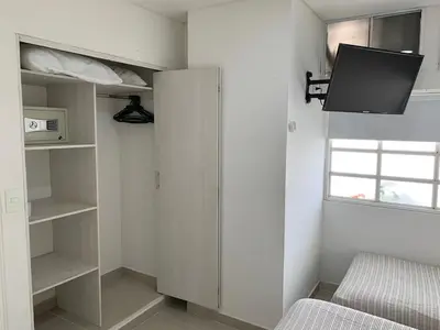 a bedroom with a bed and a tv on the wall at Portofino Cartagena Bocagrande By ICDI in Cartagena de Indias