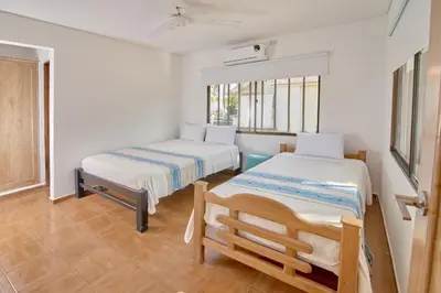 a room with two beds and a chair in it at Cabaña El Refugio in San Antero