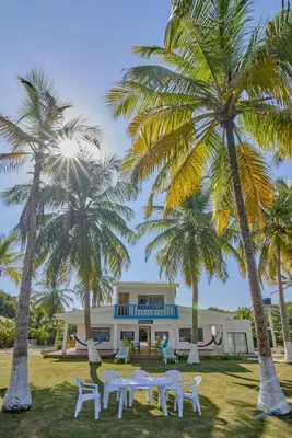 a house with palm trees in front of it at Cabaña El Refugio in San Antero