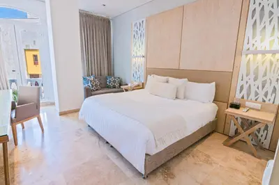 a bedroom with a large bed and a desk at GHL Arsenal Hotel in Cartagena de Indias