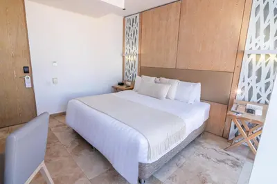 a bedroom with a large white bed in a room at GHL Arsenal Hotel in Cartagena de Indias