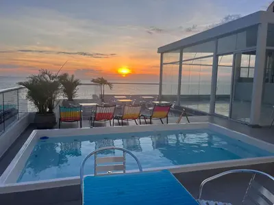 a swimming pool with a view of the ocean at Hotel Hernández CTG in Cartagena de Indias