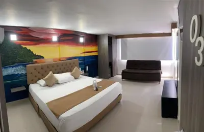 a bedroom with a bed and a painting on the wall at Hotel Hernández CTG in Cartagena de Indias