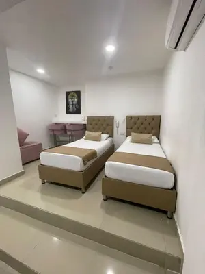 a bedroom with two beds and a couch at Hotel Hernández CTG in Cartagena de Indias
