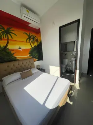 a bedroom with a large bed and a painting on the wall at Hotel Hernández CTG in Cartagena de Indias