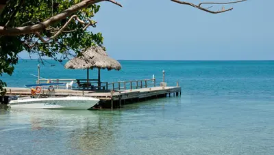 a boat is docked at a dock on the water at Hotel Punta Faro in Isla Mucura