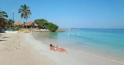 two women laying on a beach in the water at Hotel Punta Faro in Isla Mucura