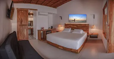 a bedroom with a large bed and a bathroom at Hotel Punta Faro in Isla Mucura