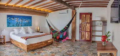 a bedroom with a bed and a hammock in it at Hotel Punta Faro in Isla Mucura