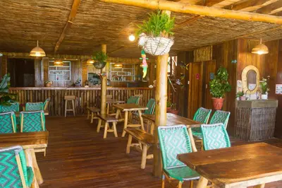 a restaurant with wooden tables and chairs and a bar at Hotel Calamari Baru in Playa Blanca