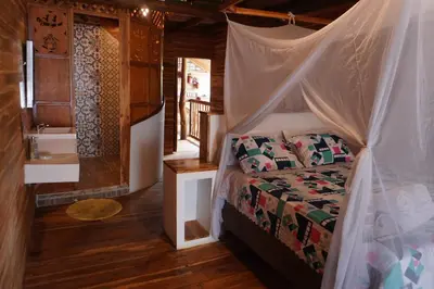 a bedroom with a bed with a mosquito net at Hotel Calamari Baru in Playa Blanca