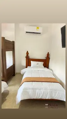 a bedroom with a large bed with a air conditioner at Hostal La Heroica in Cartagena de Indias