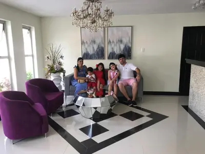 a family sitting on a couch in a living room at Hotel Prado Real in Barranquilla