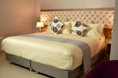 a bedroom with a large bed with a white bedspread and pillows at Hotel Prado Real in Barranquilla