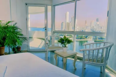 a bedroom with a bed and two chairs and a window at Torres del Lago B-2 in Cartagena de Indias
