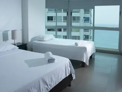 a hotel room with two beds and a large window at Torres del Lago B-2 in Cartagena de Indias