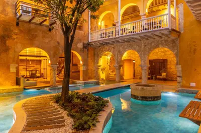 an indoor pool with a tree in a building at Casa Carolina Luxury Wellness Hotel in Cartagena de Indias