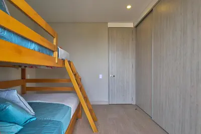 a small bedroom with a bunk bed with a ladder at Cielo Mar Regatta - LivinColombia in Cartagena de Indias