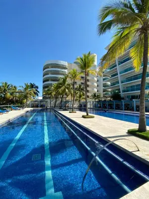 a swimming pool with palm trees and a building at Cartagena Boquilla Morros playa apt 1 in Cartagena de Indias