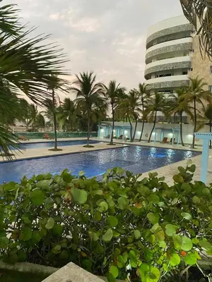 a swimming pool with palm trees and a building at APTO EN LA BOQUILLA CARTAGENA MORROS 922 in Cartagena de Indias